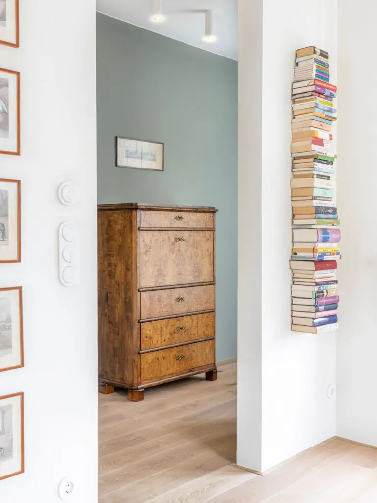 Heller Flur mit antikem Holzschrank und modernem Bücherturm, gestaltet von Stephanie Loy Interior Design