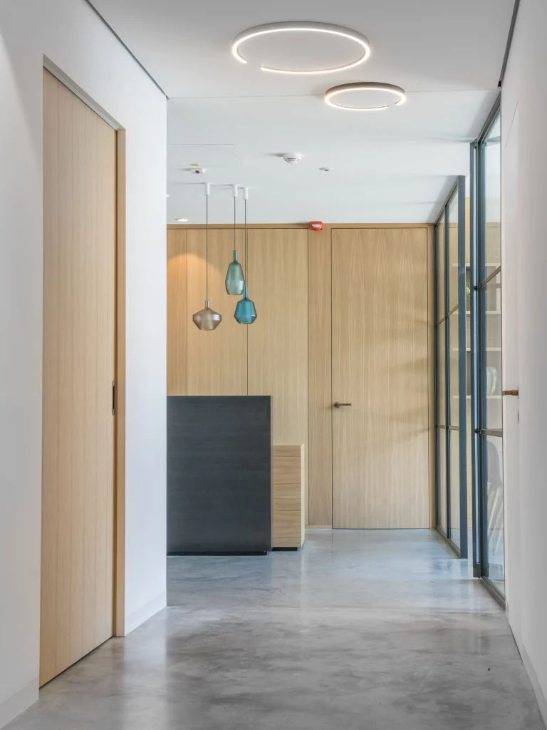 Moderne Praxisräume mit Holzelementen und schwarzem Tresen, gestaltet von Stephanie Loy Interior Design